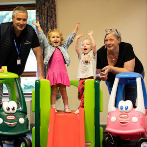 Two adults and two children stood around donated toys.