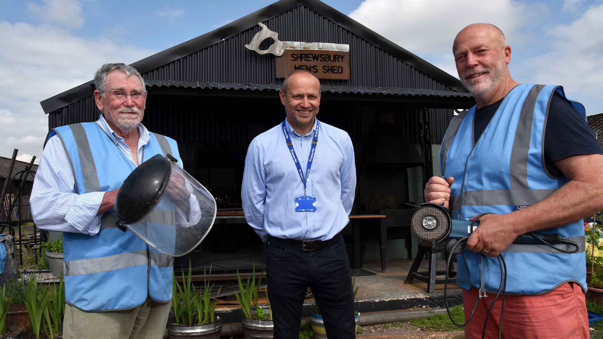 Three men standing outside of Shrewsbury Men's Shed.